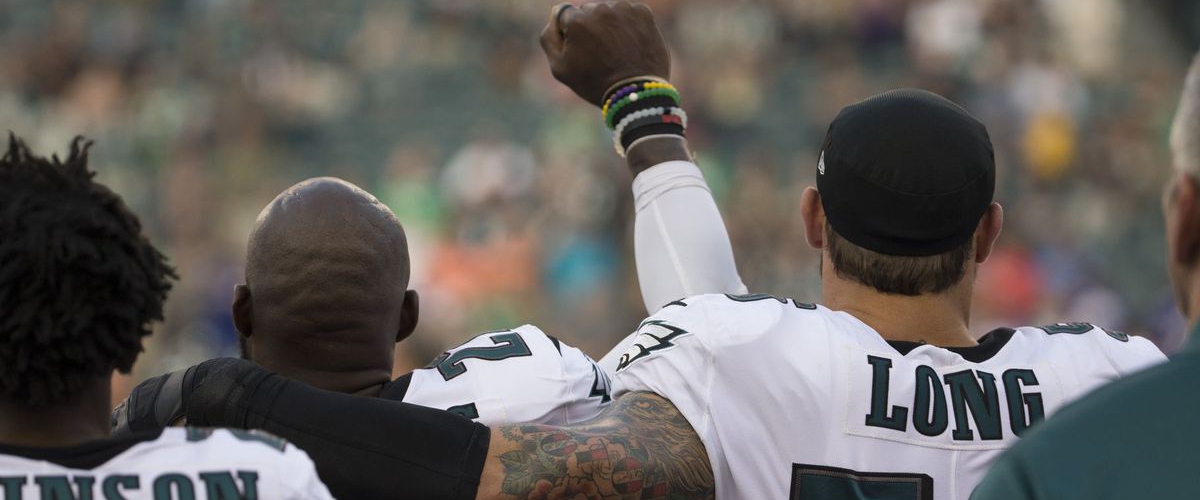 Chris Long shows support for teammate by putting his arm around him during national anthem 